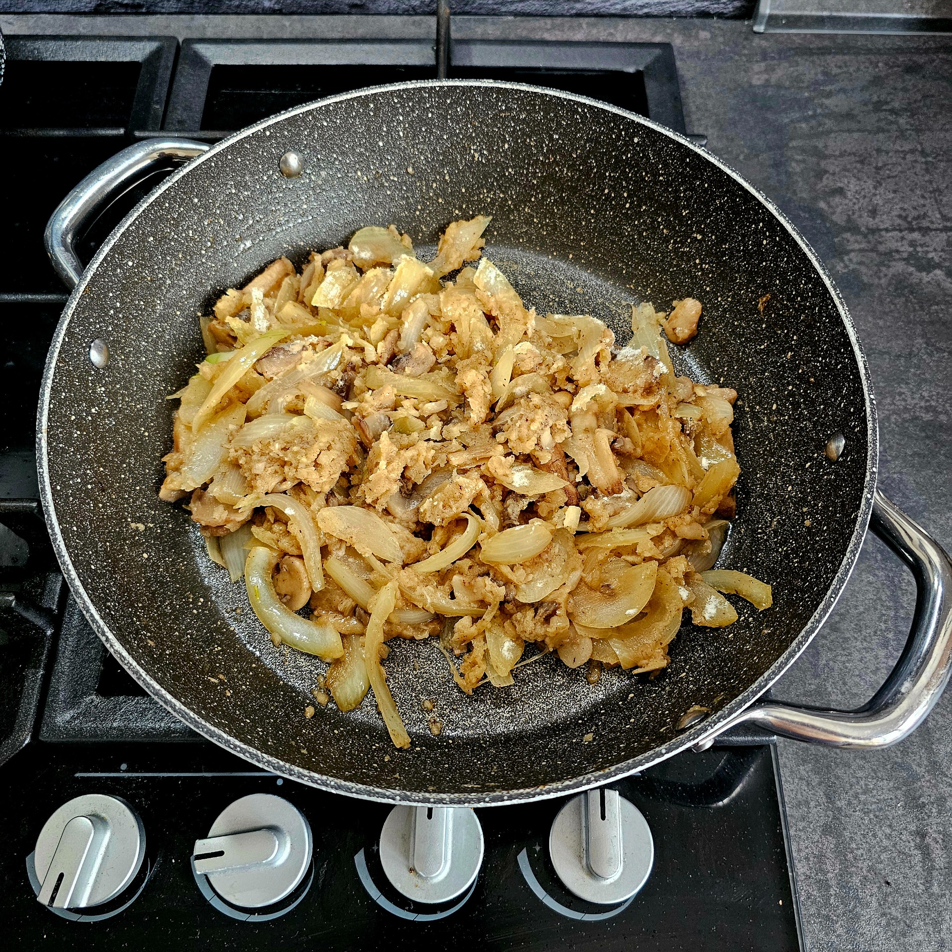 Přidejte nakrájené žampiony, mouku a krátce orestujte.