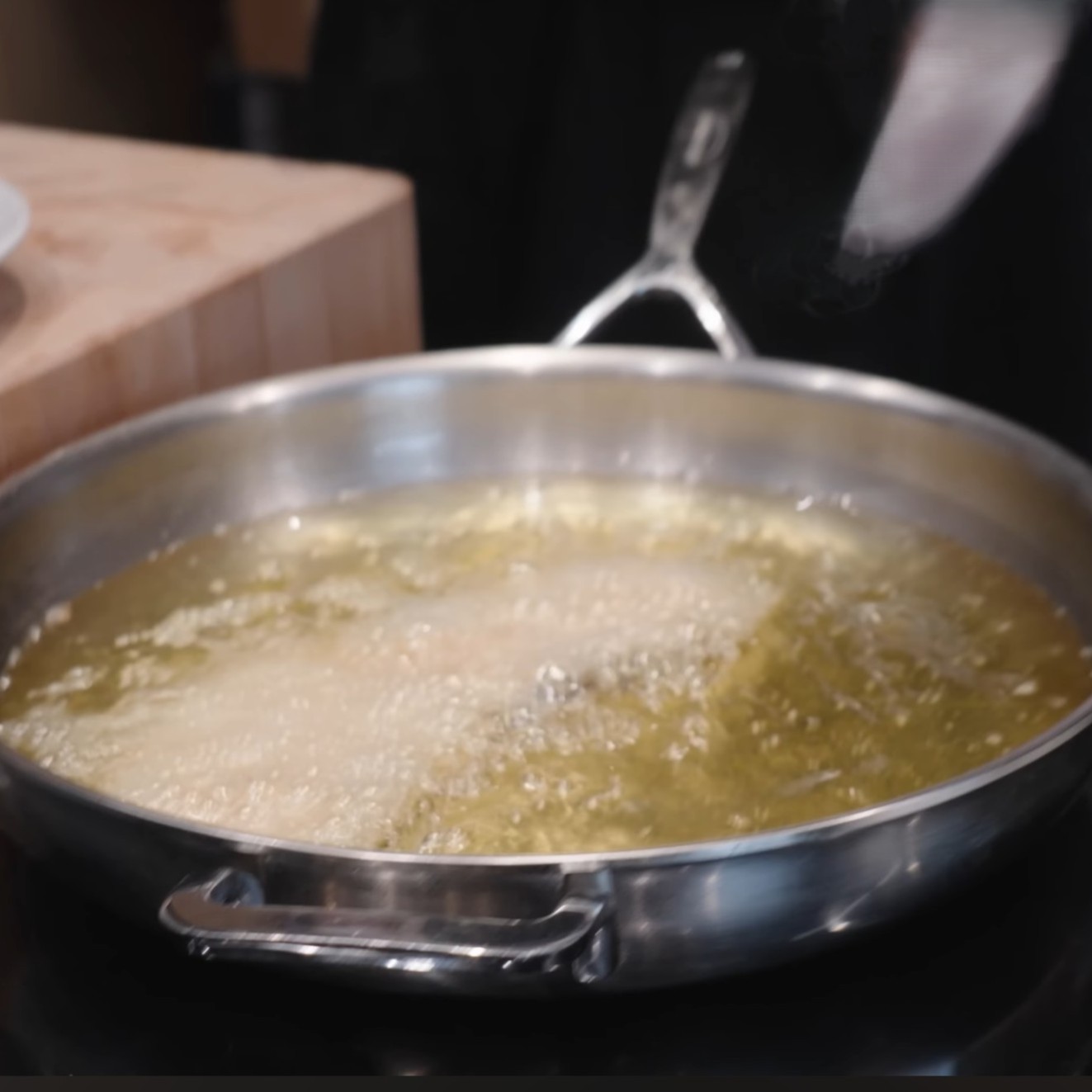 Smažení řízku v tuku v dostatečném množství a při správné teplotě.