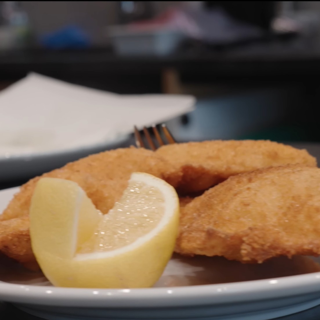 Hotový vídeňský telecí řízek se zlatavou krustou a citronem.