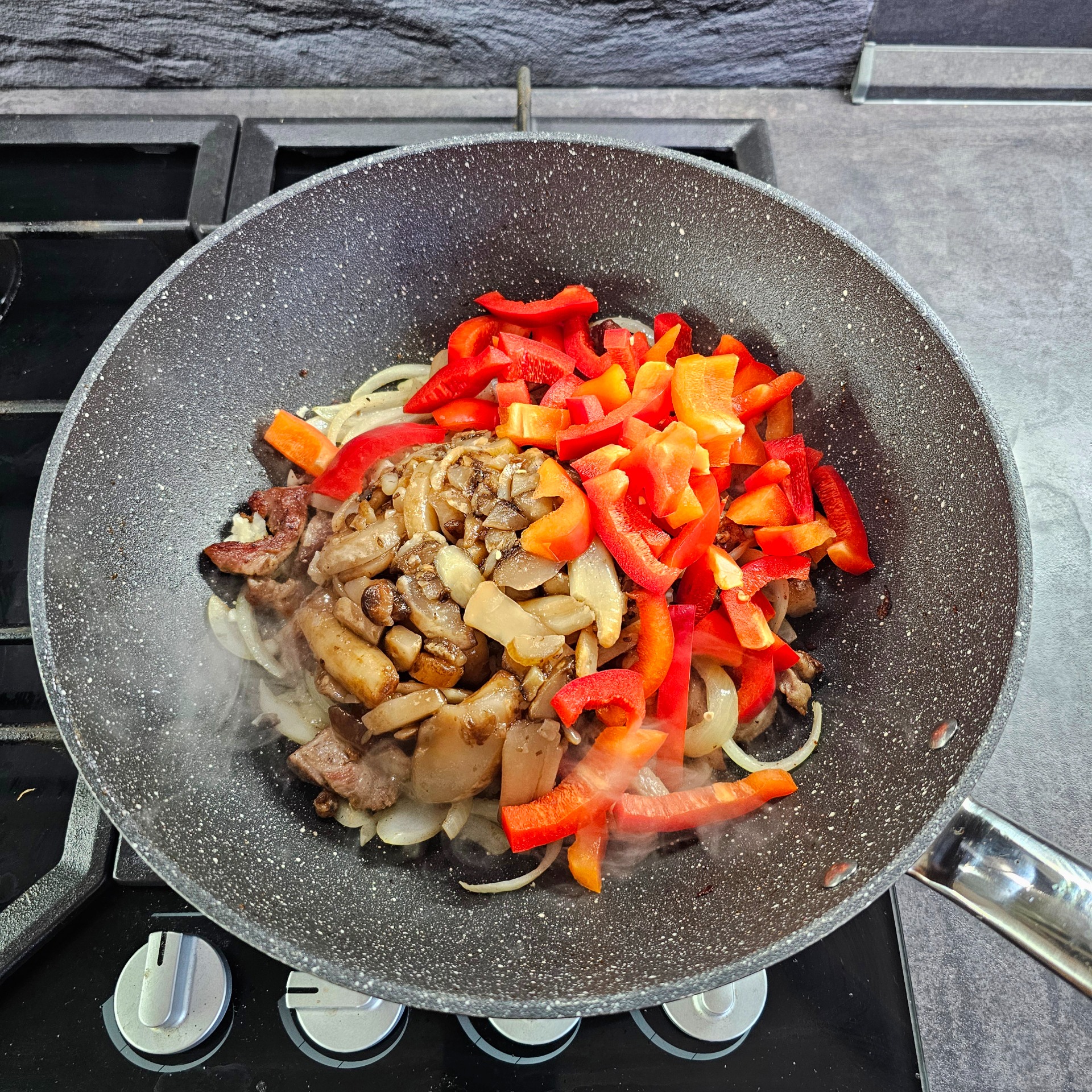 Přidáme cibuli, česnek, žampiony a zeleninu. 