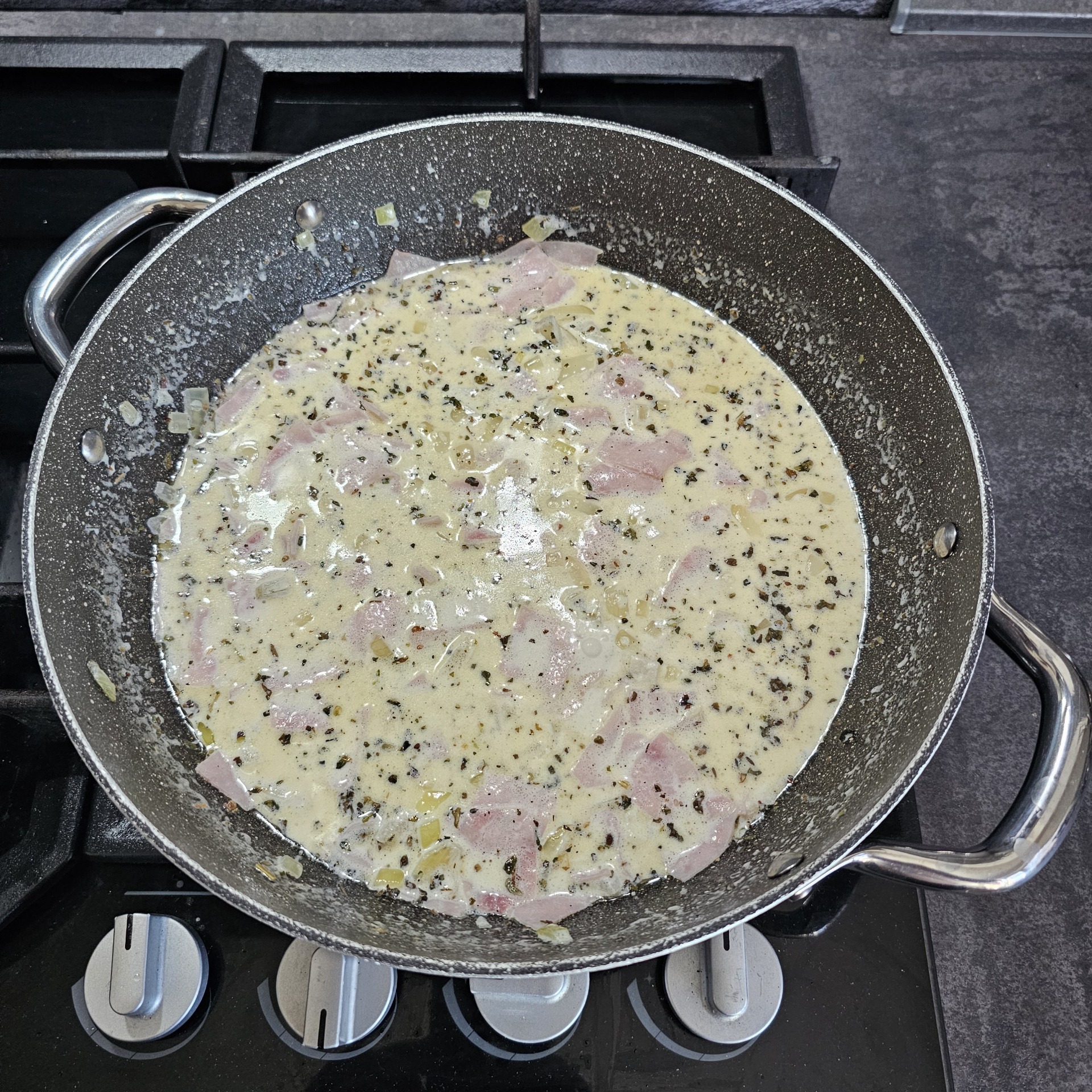 Přidáme šunku, smetanu, mléko a bazalku.
